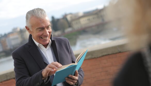 man reading and smiling in the street